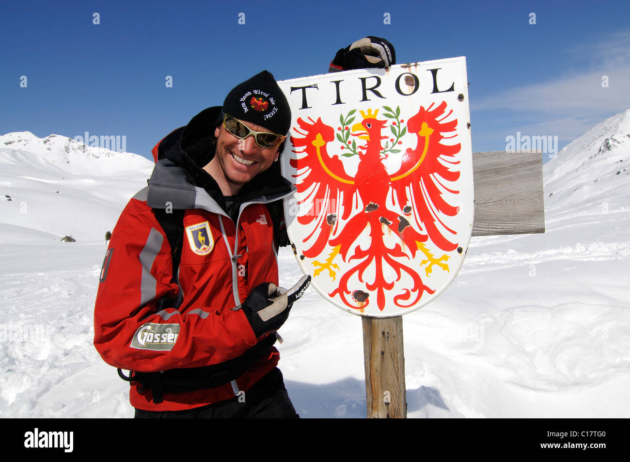 Kitzbuehl ski instructor, alpine guide from Red Devils at Tyrol border sign, Markkirchl, Salzachjoch, Kelchsau, Tyrol, Austria Stock Photo