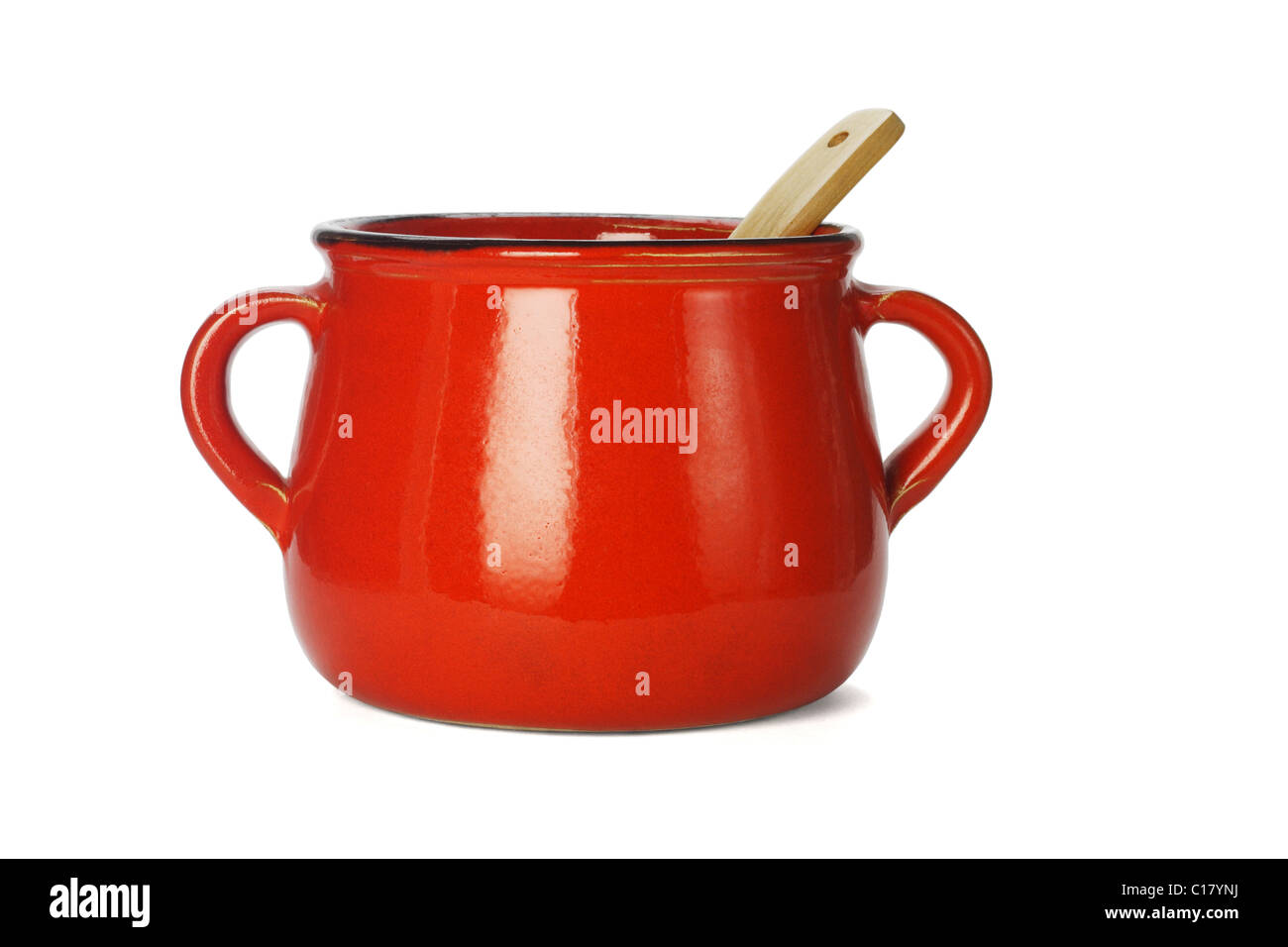 Red clay pot with wooden ladle on white background Stock Photo