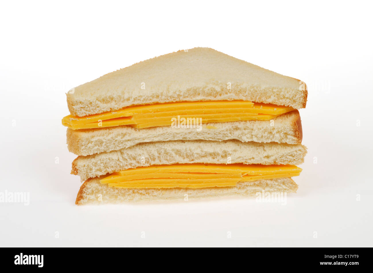 Cheese sandwich with  slices of yellow cheese on white bread cut in half stacked on white background, cutout. Stock Photo