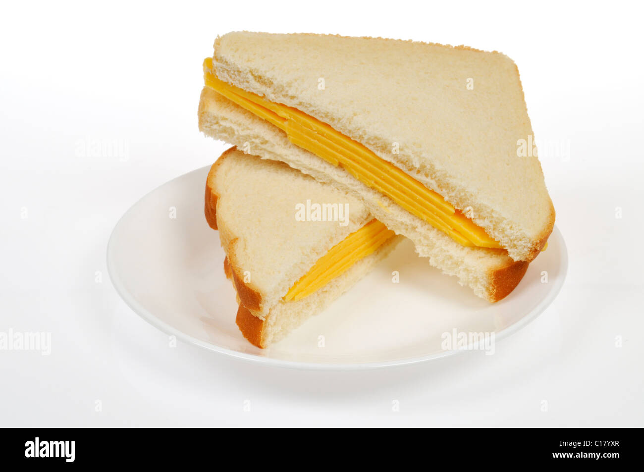 Cheese sandwich with 2 slices of cheese on white bread cut in half on white plate on white background, cutout. Stock Photo