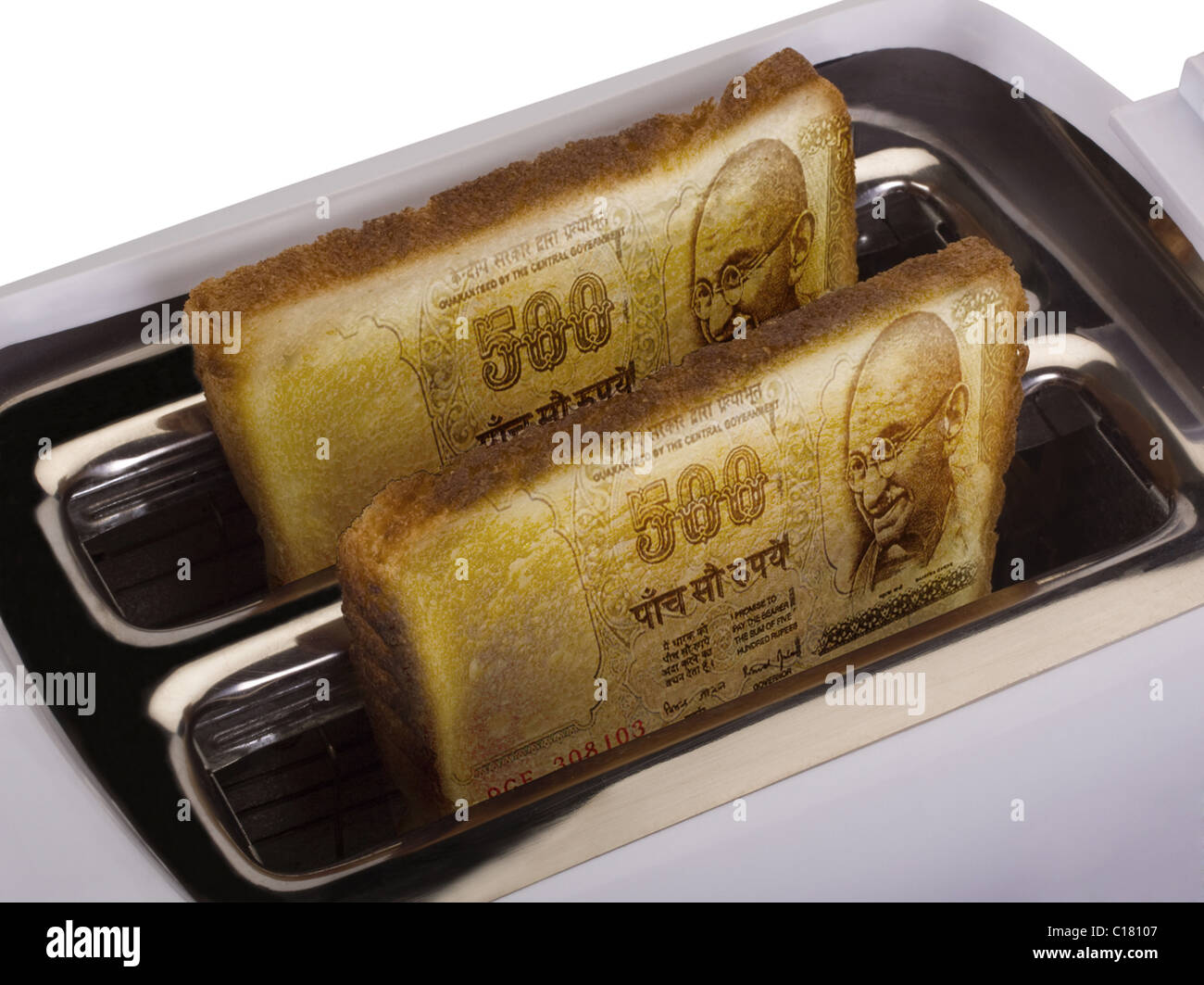 Toast of Indian currency popping out from a toaster Stock Photo