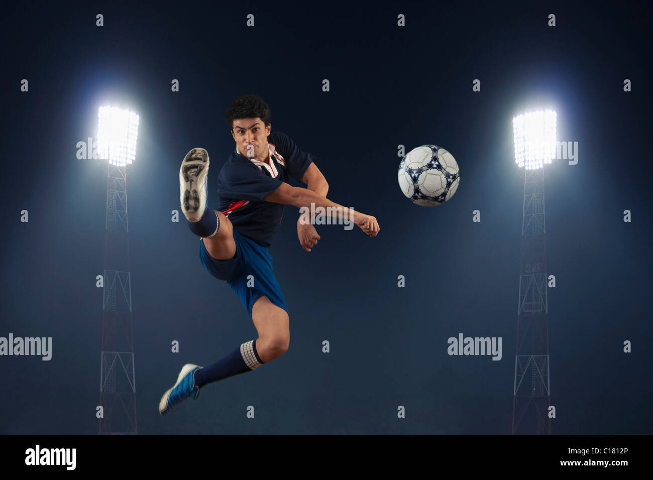 Soccer player kicking a soccer ball Stock Photo