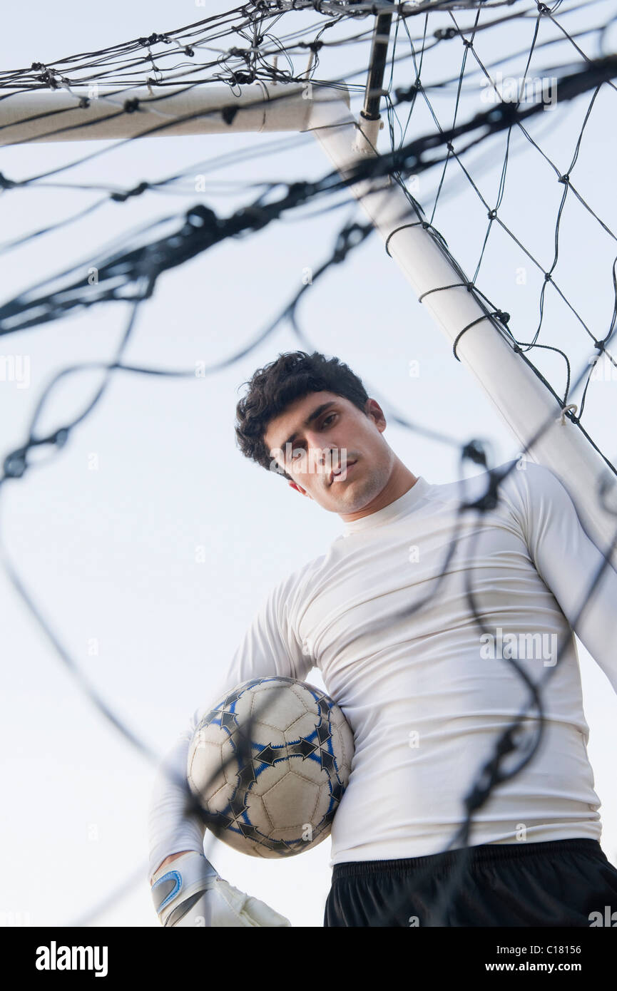 Goalie holding the soccer ball at the goal post Stock Photo Alamy