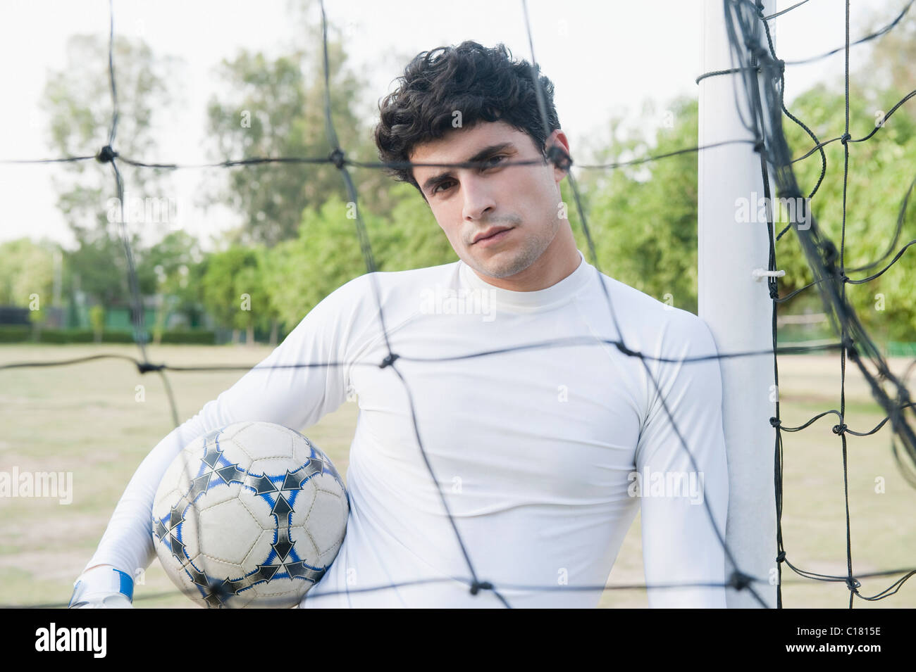 Goalie holding the soccer ball at the goal post Stock Photo Alamy