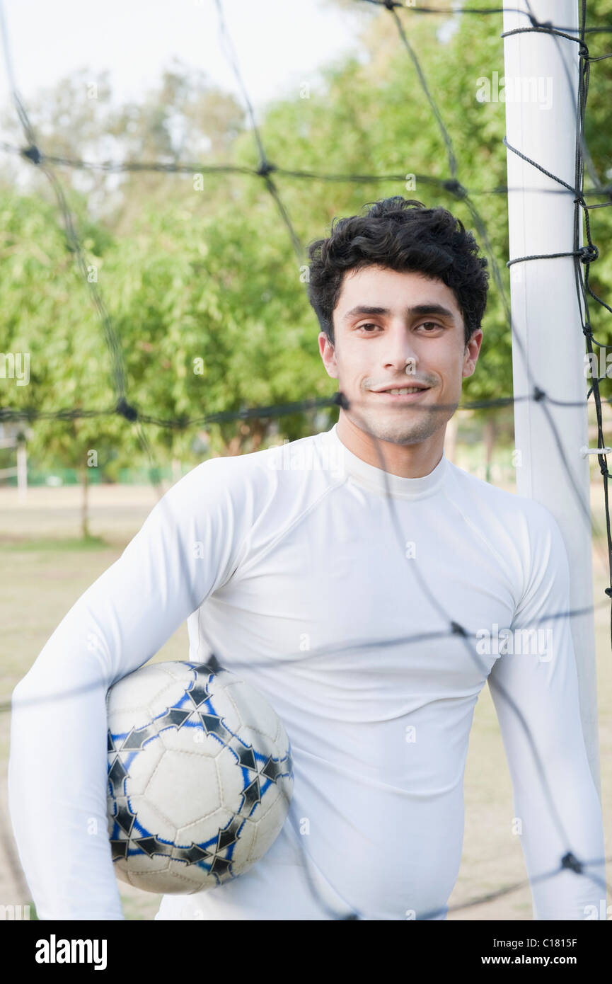 Goalie holding the soccer ball at the goal post Stock Photo Alamy