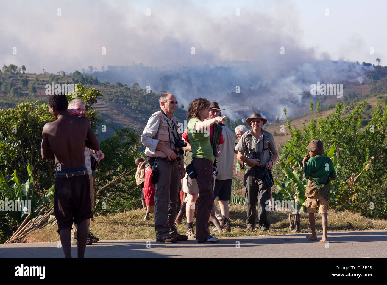 Tourists witnessing a slash and burn fire from RN 7 Highway in south central Madagascar. Stock Photo