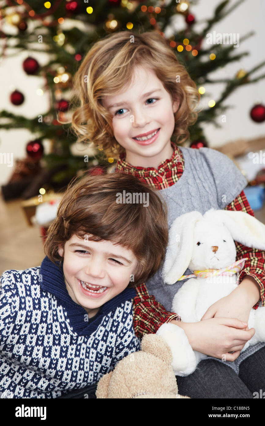 Kids laughing in front of xmas tree Stock Photo