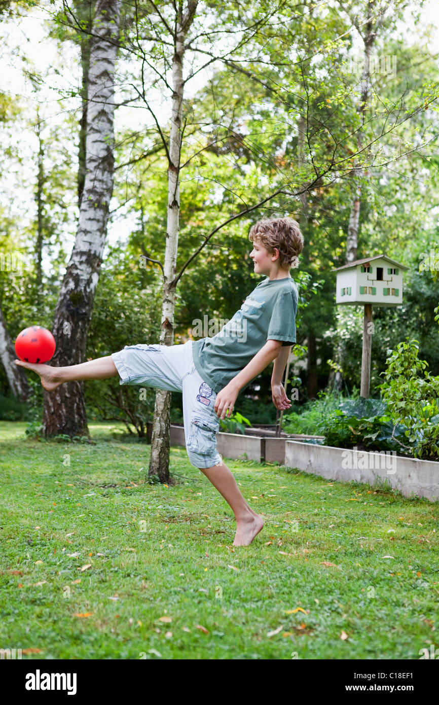 Boy playing with ball in the garden Stock Photo Alamy