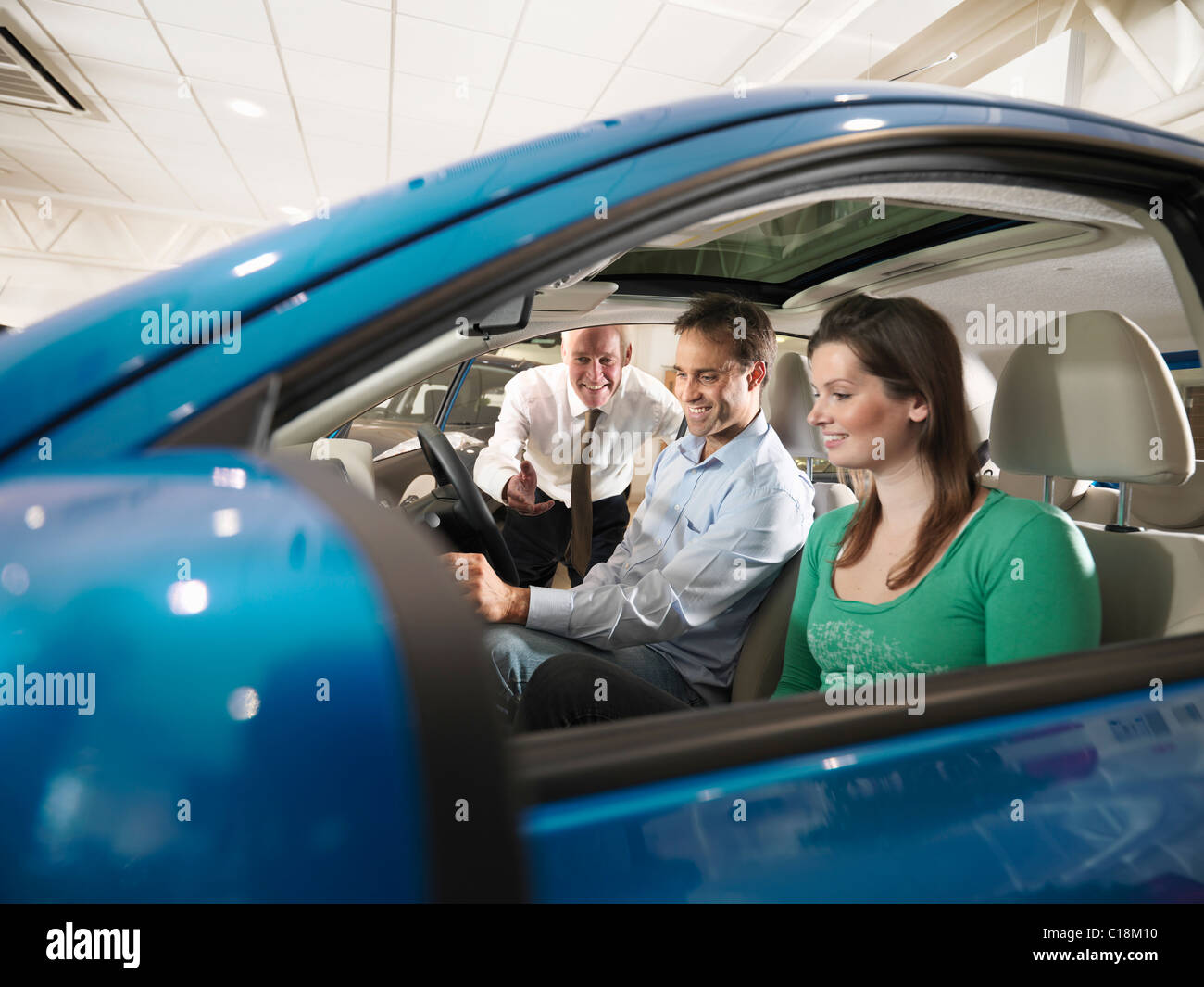 Salesman shows customers a car Stock Photo