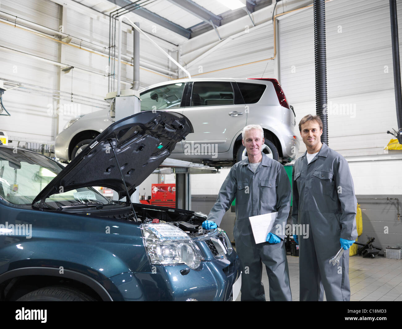Mechanics working in car dealership Stock Photo Alamy