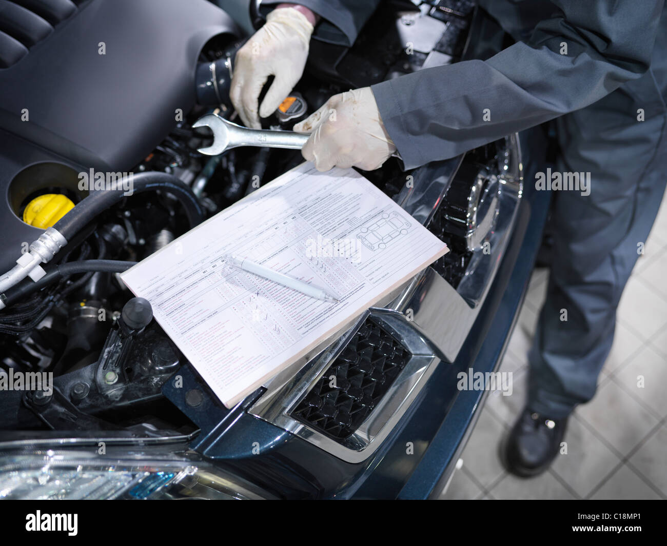 Mechanic checks list in car dealership Stock Photo
