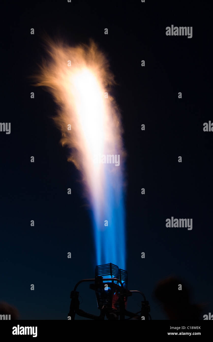 The propane burner of a hot air balloon lights up the night sky Stock