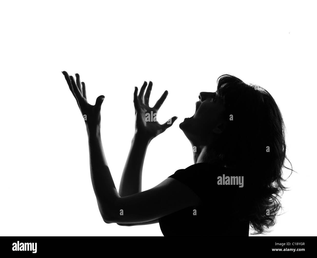 portrait silhouette in shadow of a young woman screaming anger  in studio on white background isolated Stock Photo