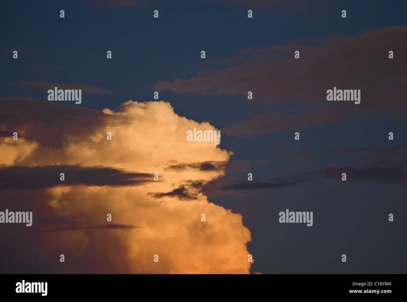 View of a large cumulus cloud through altostratus at sunset Stock Photo