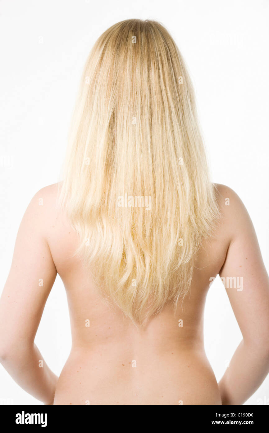 Young, long-haired blonde woman, bare upper body, in front of white backdrop Stock Photo