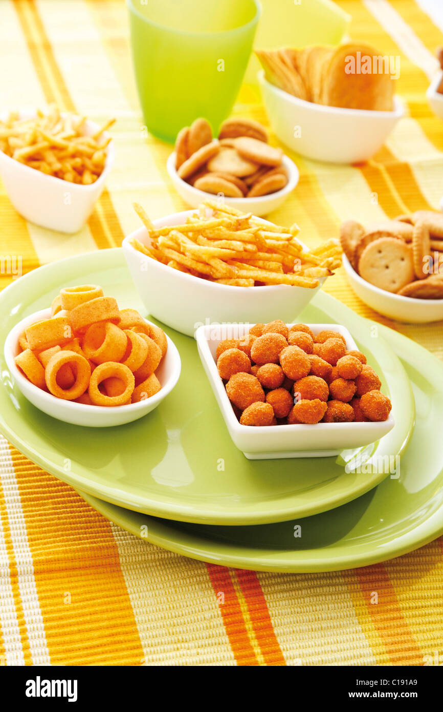 Various spiced snacks in bowls, crisps, peanut flips, potato sticks