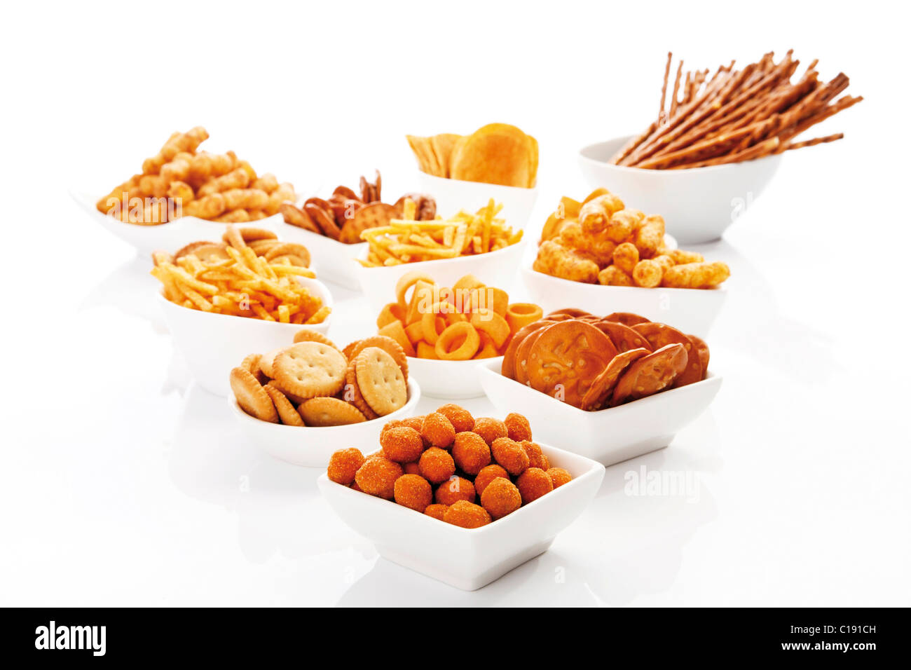 Various spiced snacks in bowls, crisps, peanut flips, pretzel sticks, potato sticks and salted cookies Stock Photo