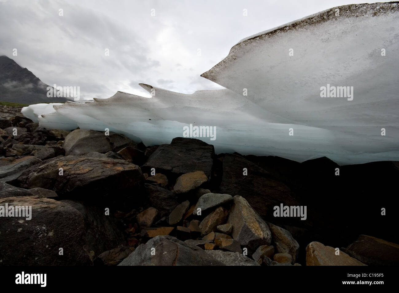 Ice edge of glacier over stones. Siberia. Tunkinskie Goltsy area. Eastern Sayan mountains. Buryat Republic. Russia. Stock Photo