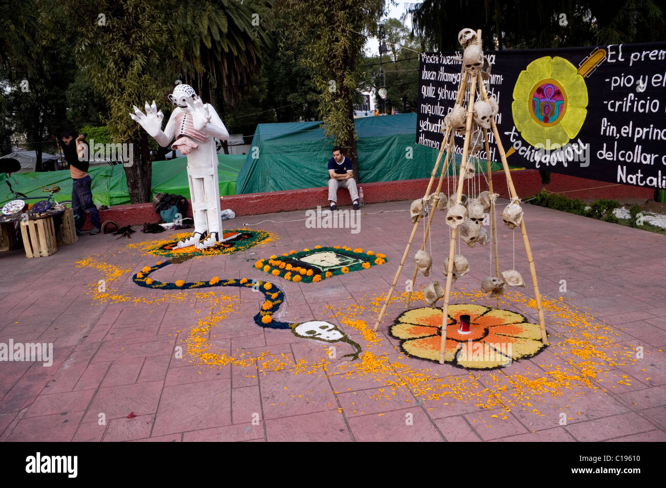 Day of the dead altar with flowers, skulls and a sculpture of the Aztec ...