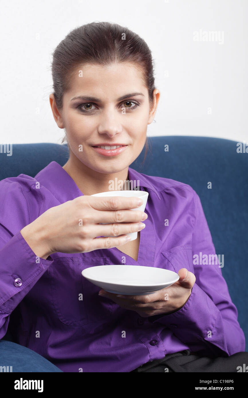 Pretty young businesswoman having a coffee break in the office Stock Photo