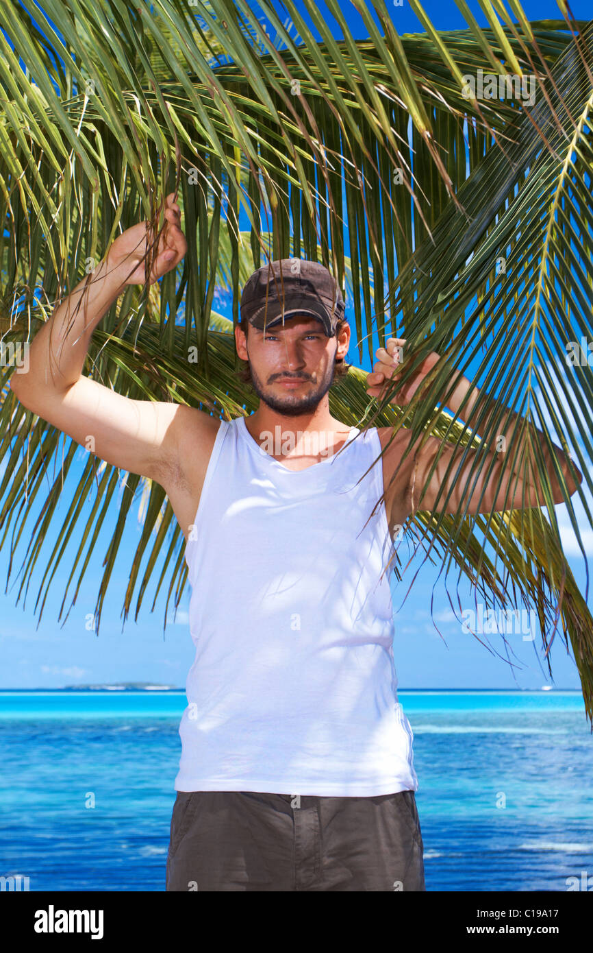 Handsome man is stanging next to palm tree Stock Photo - Alamy