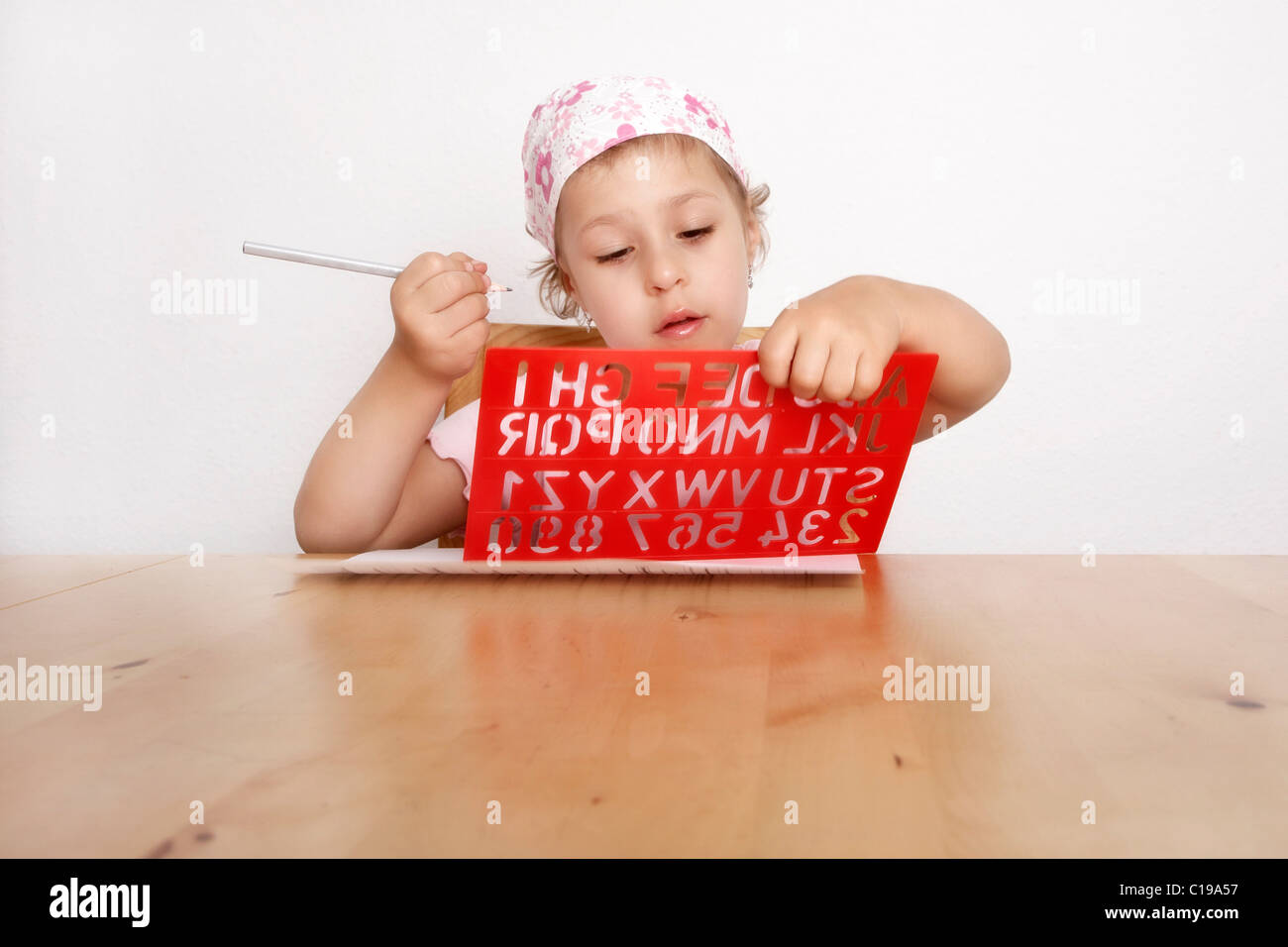 Girl, 6, holding a lettering template Stock Photo