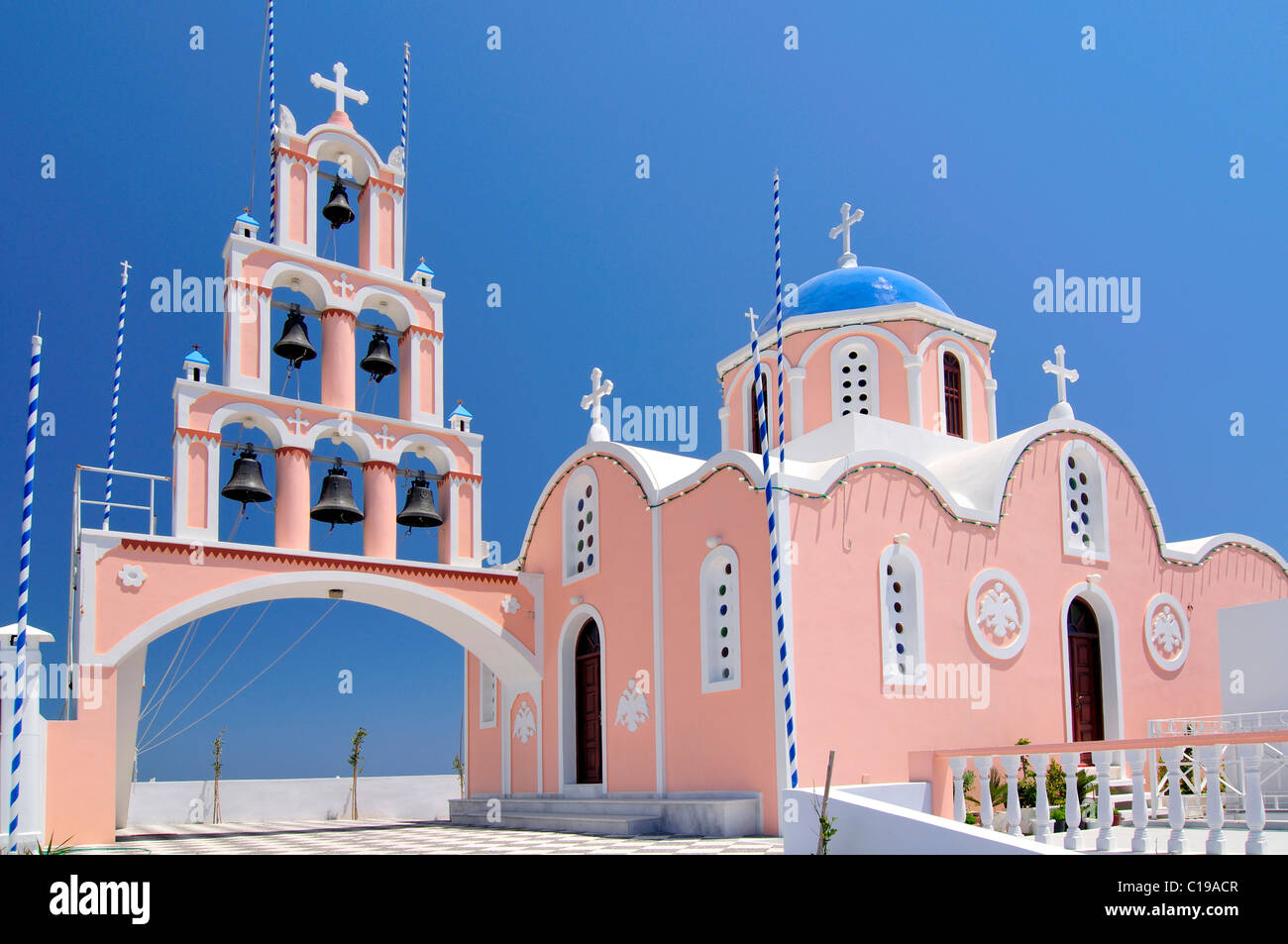 Bell tower with six bells and a pink and light blue Greek church Karterados, Santorini, Cyclades, Greece, Europe Stock Photo