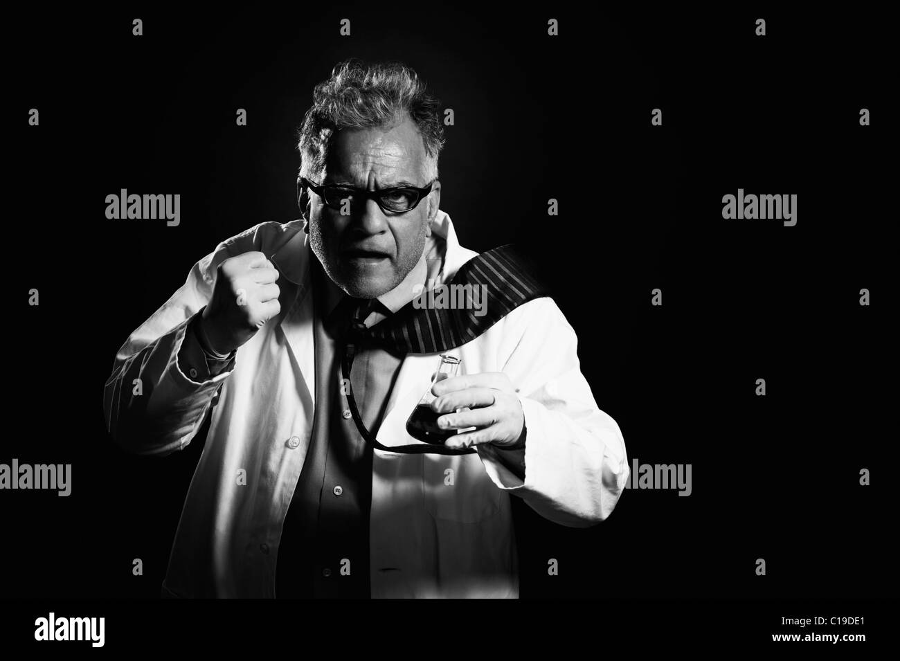 Scientist holding chemical flask and showing his fist Stock Photo