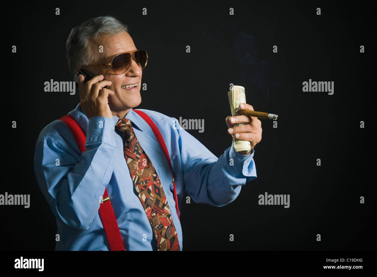Man talking on a mobile phone and holding money Stock Photo