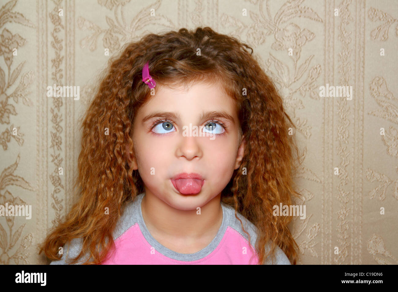 funny girl face ugly expression cross-eyed squinting on retro wallpaper Stock Photo