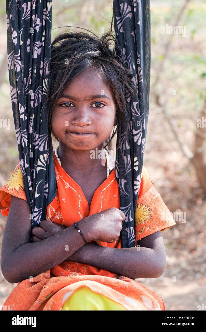 Happy young poor lower caste Indian street girl smiling sat in a sari swing. Andhra Pradesh, India Stock Photo
