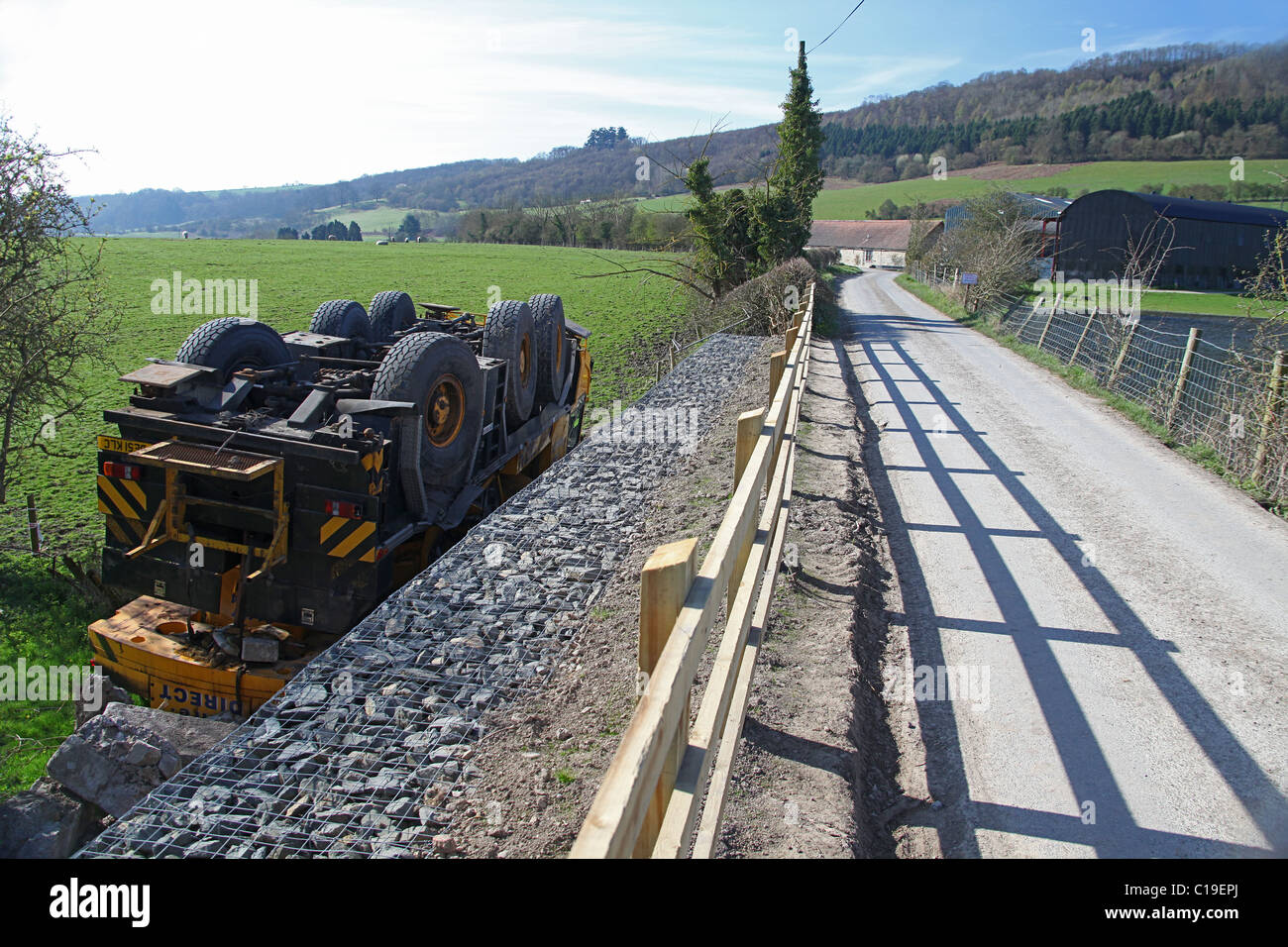 An overturned lorry mounted crane lies in a field at Stokesay,  Shropshire, England, UK Stock Photo