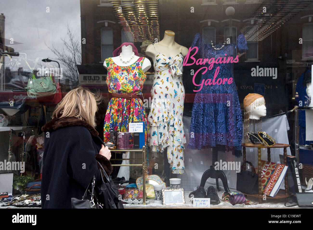 Woman looking in Charity shop window Stock Photo - Alamy