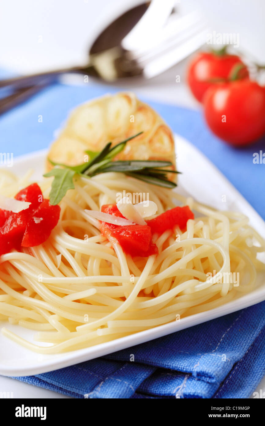 Spaghetti, peeled tomato and baked garlic - detail Stock Photo