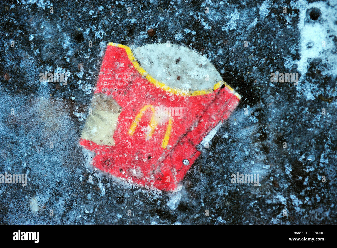 A McDonalds carton lies frozen to the ground in Glasgow during the coldest winter to hit Scotland for decades. Stock Photo