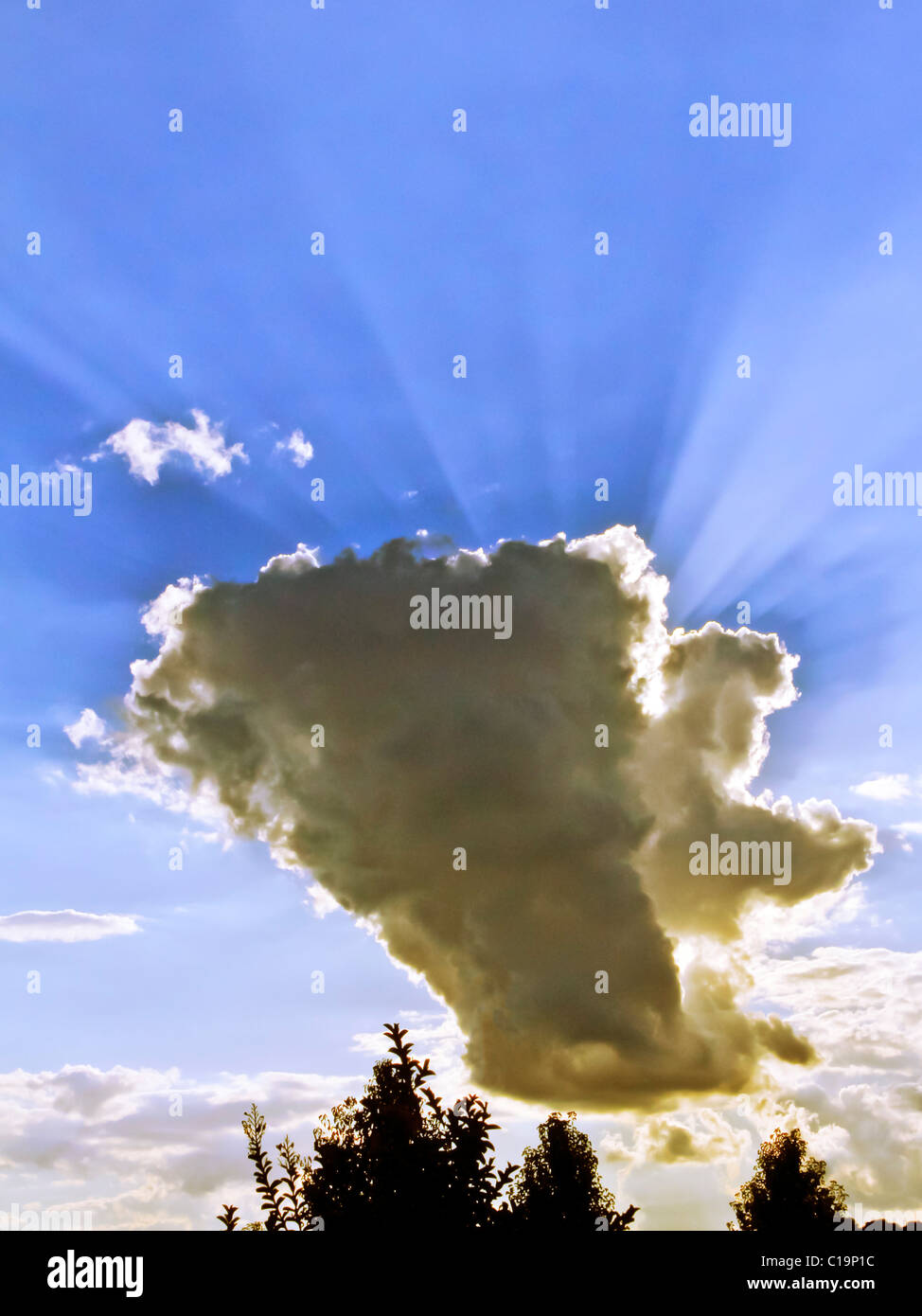 Spectulay Cumulonimbus cloud formation with sun behind projecting light rays. Stock Photo