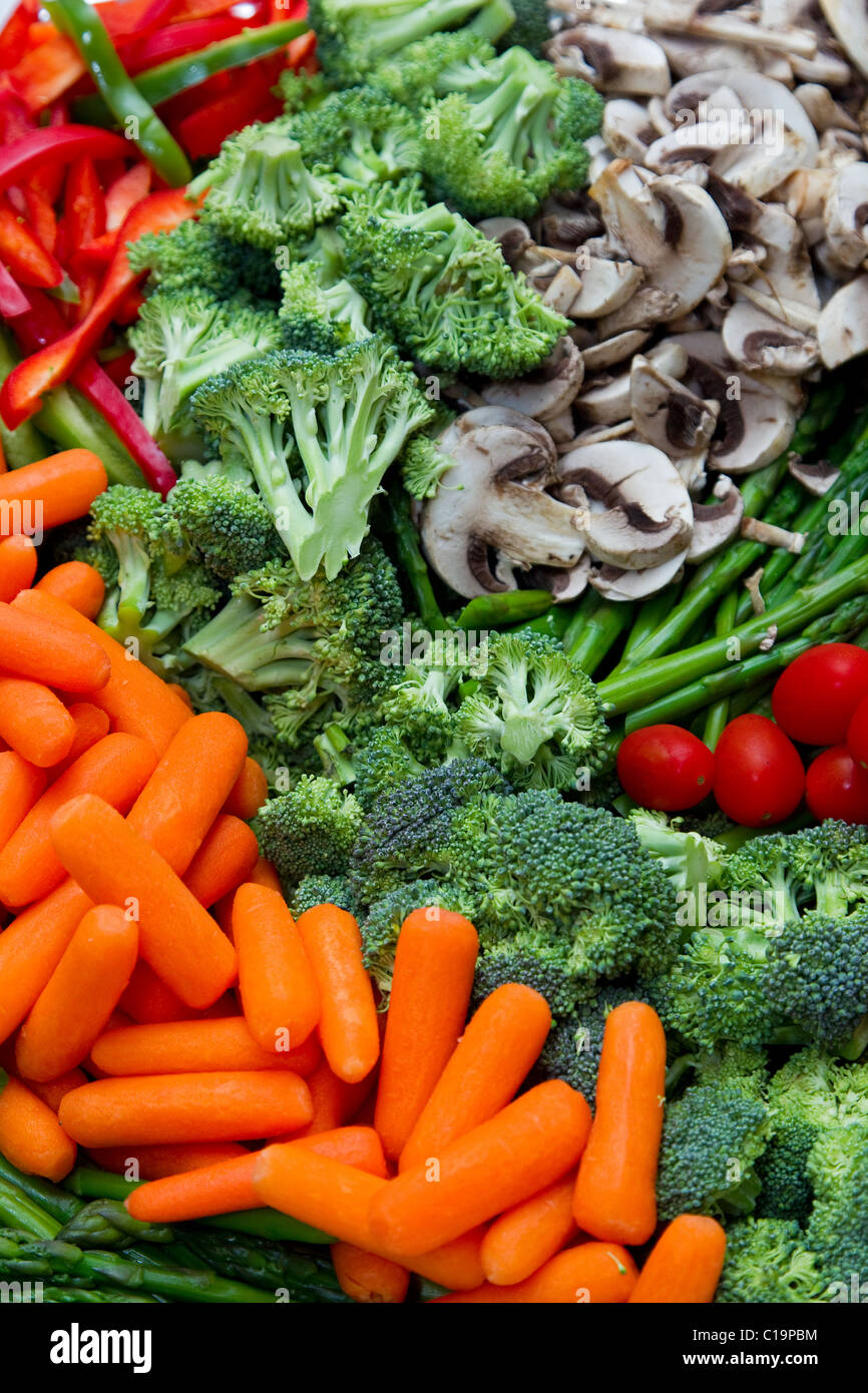 Bright, colorful fresh raw vegetables, carrots, broccoli, mushrooms, cherry tomatoes and red bell peppers in a fresh design Stock Photo