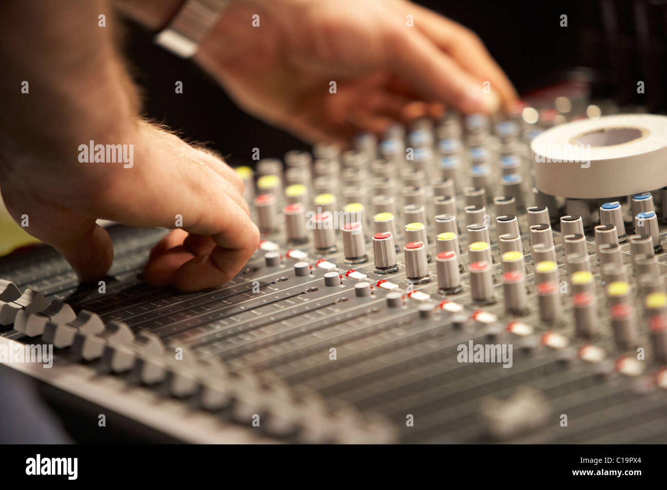 sound engineer adjusting audio mixing desk in a theatre concert hall Stock Photo