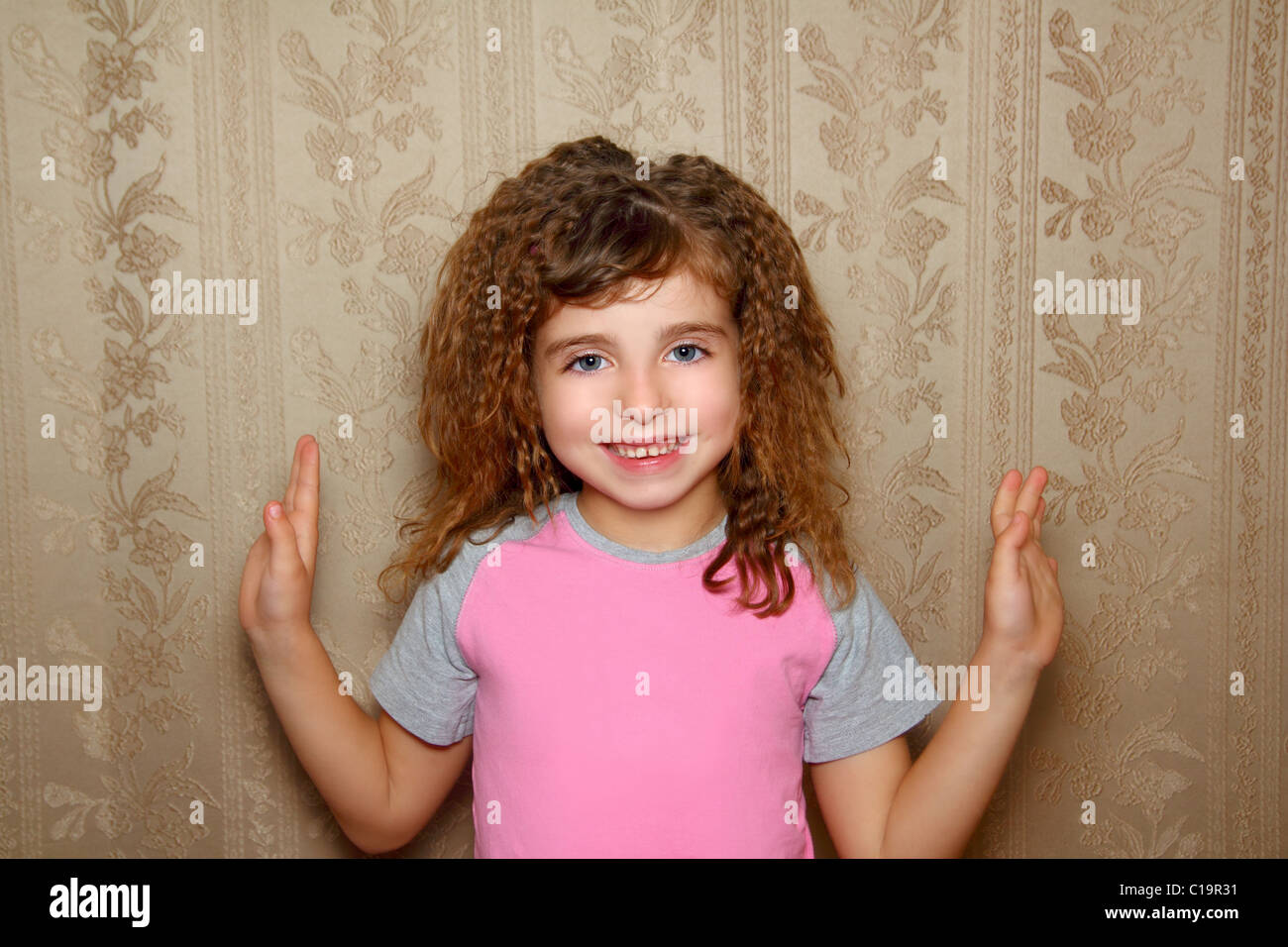 little girl happy funny expression on vintage retro wallpaper Stock Photo