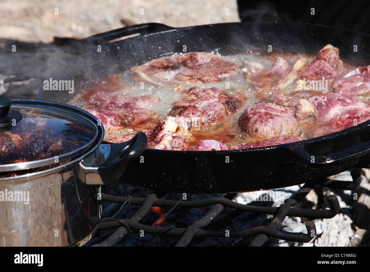 Cooking Lamb chop steaks and Mutton cooking in cast iron pans over an