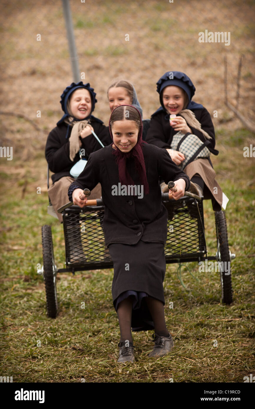 Amish girls play on a buggy during the Annual Mud Sale to support the Fire Department Stock Photo