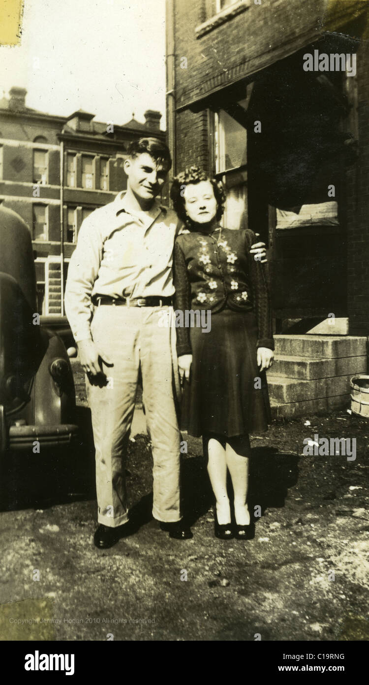 portrait of man and woman standing next to car in the mid 1940s WWII era Indiana Stock Photo