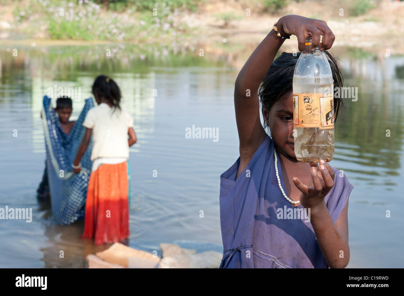 Poor indian lower caste children fishing in the river with a sari and ...