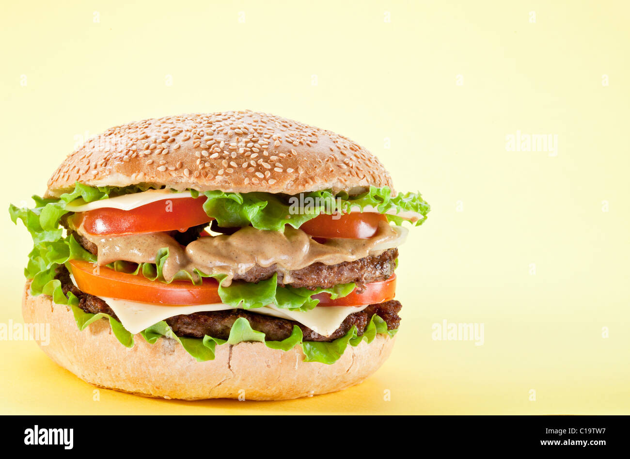 Tasty hamburger on yellow background. Stock Photo