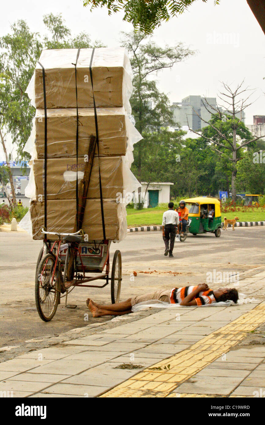 A rickshaw puller is taking rest at road side of New Delhi ( India