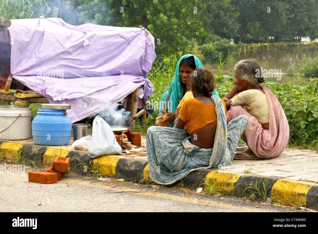 Flood effected womens are making their meal at the road side of Yamuna Bank ,New Delhi ( India ) Stock Photo