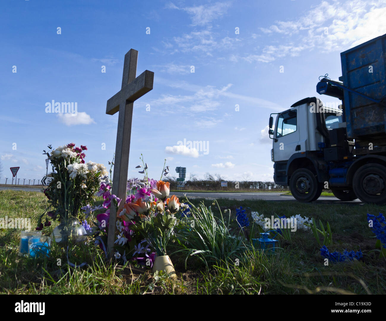 HGV passing a makeshift shrine at a main road accident blackspot. Stock Photo