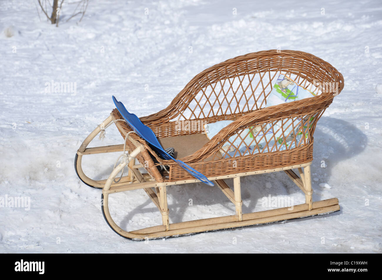 Children's wicker sled stand in the snow Stock Photo