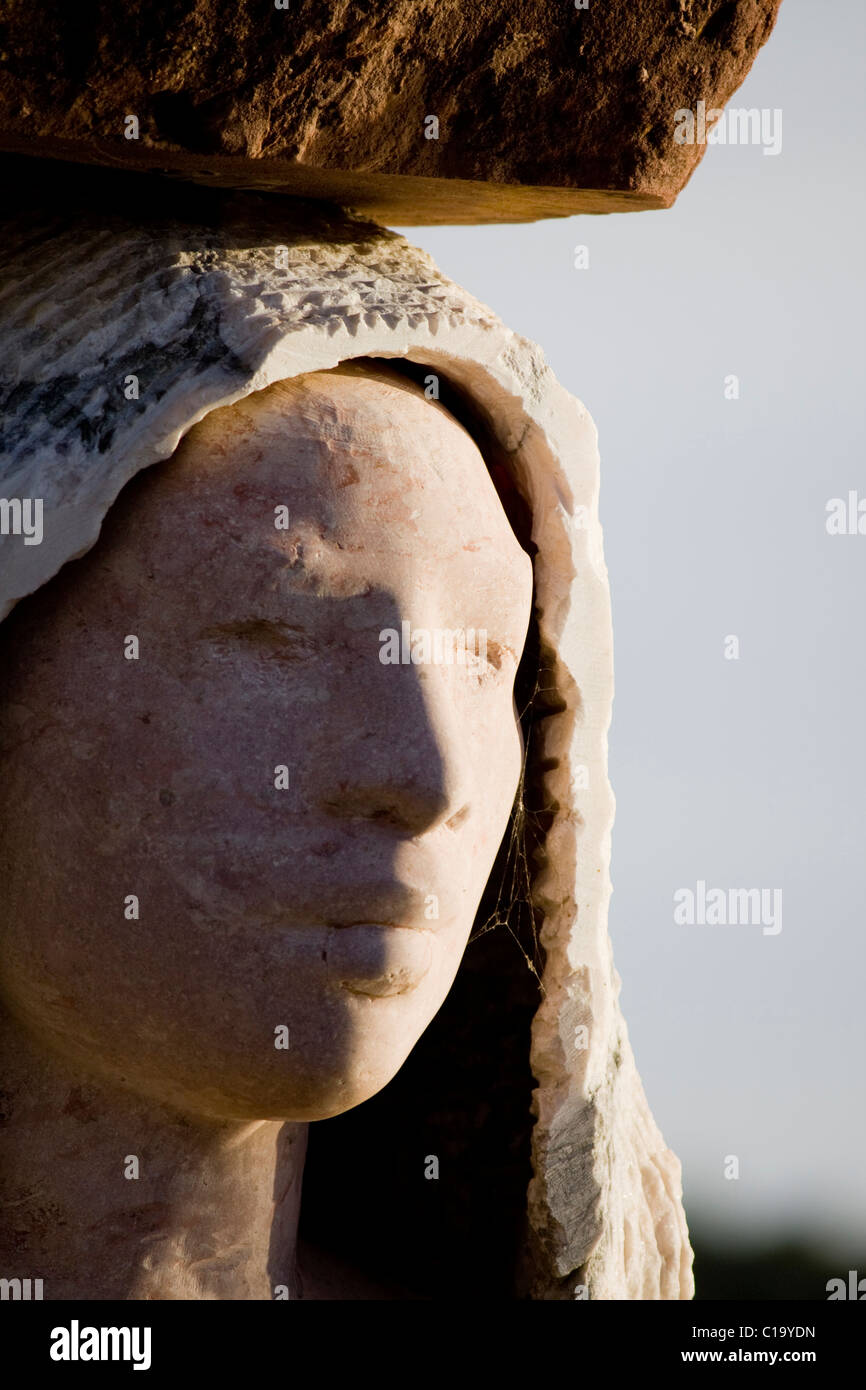 Closeup view of a stone statue face of a young woman. Stock Photo