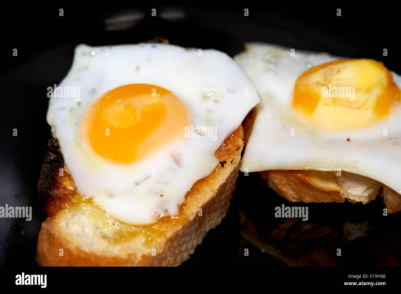 fried quails eggs on buttered toasted bread Stock Photo
